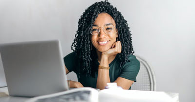 Young woman at her laptop smiling