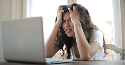 Young woman at her laptop smiling